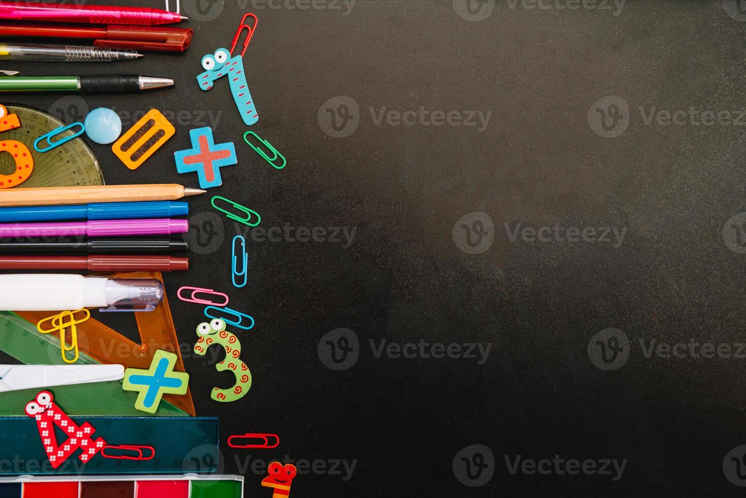 Back to school concept. School and office supplies on blackboard background. Flat lay with copy space photo