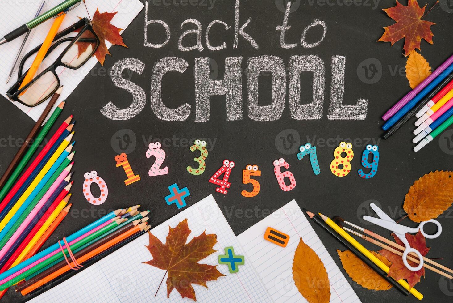 Back to school concept. School and office supplies on blackboard background photo