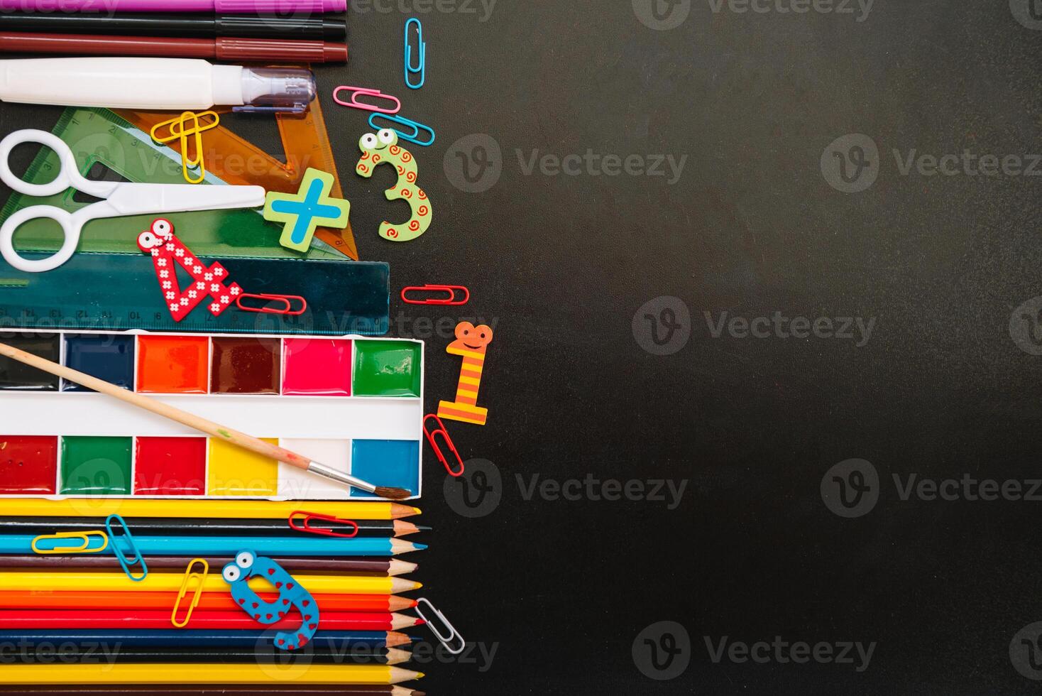 Back to school concept. School and office supplies on blackboard background. Flat lay with copy space photo