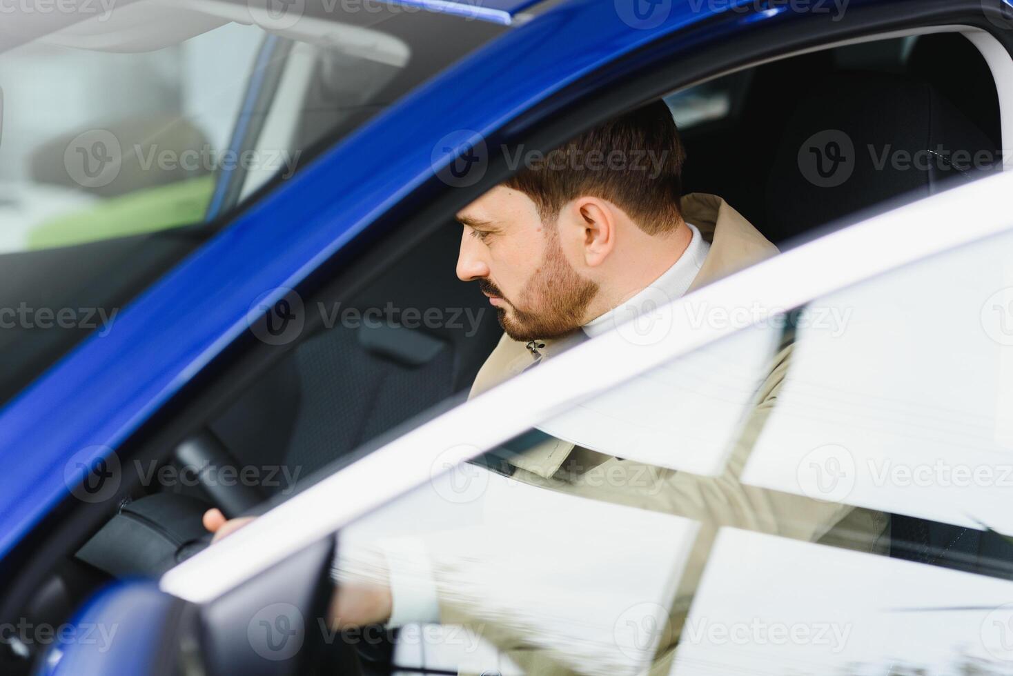 Handsome elegant serious man drives a car photo