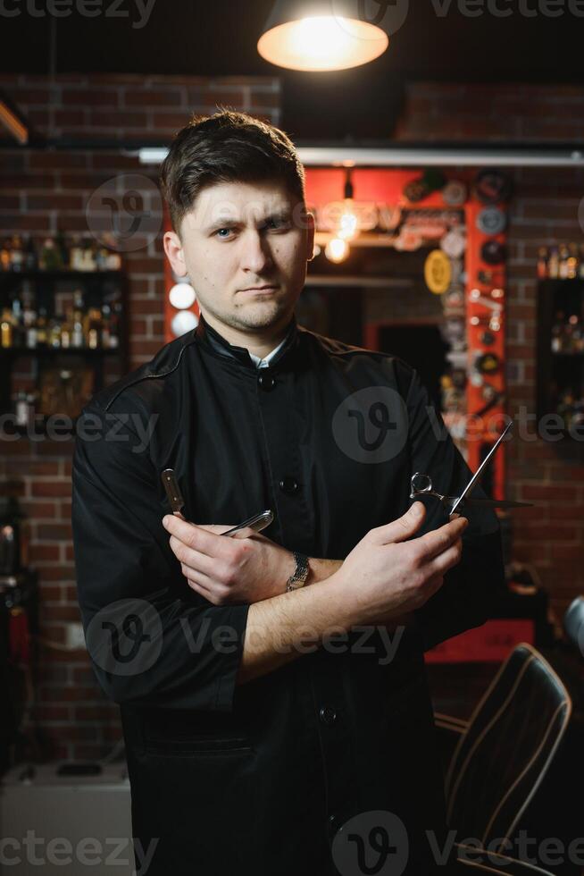 Hairdresser. Salon for men. Barbershop concept. Handsome man with barber tools. Professional beard and hair care. photo