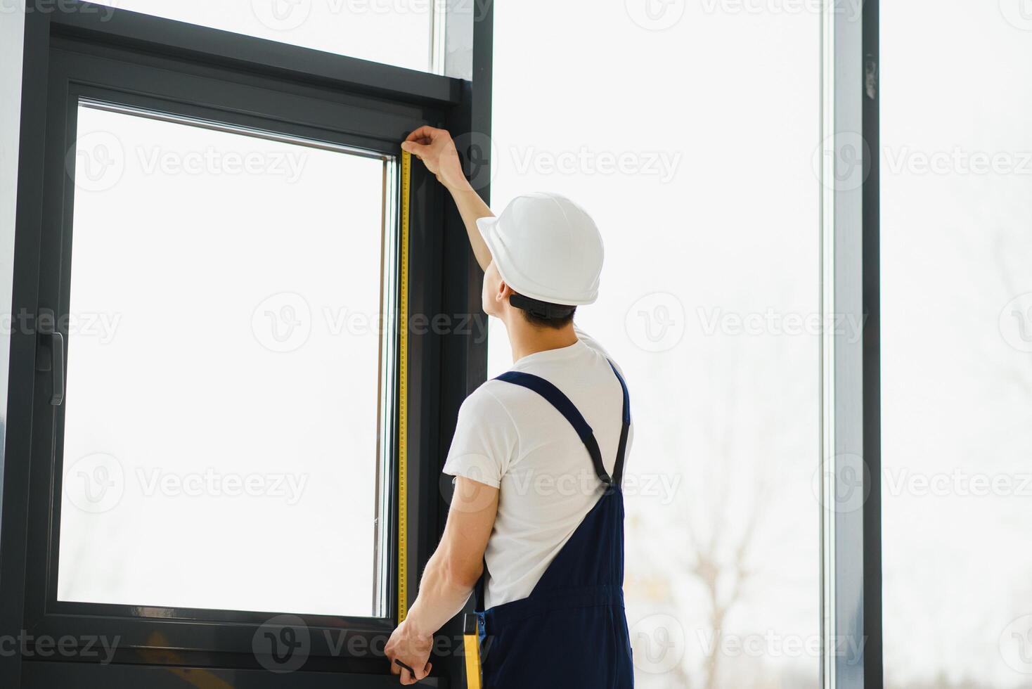 male industrial builder worker at window installation in building construction site photo