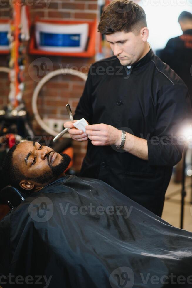 Visiting barbershop. African American man in a stylish barber shop photo