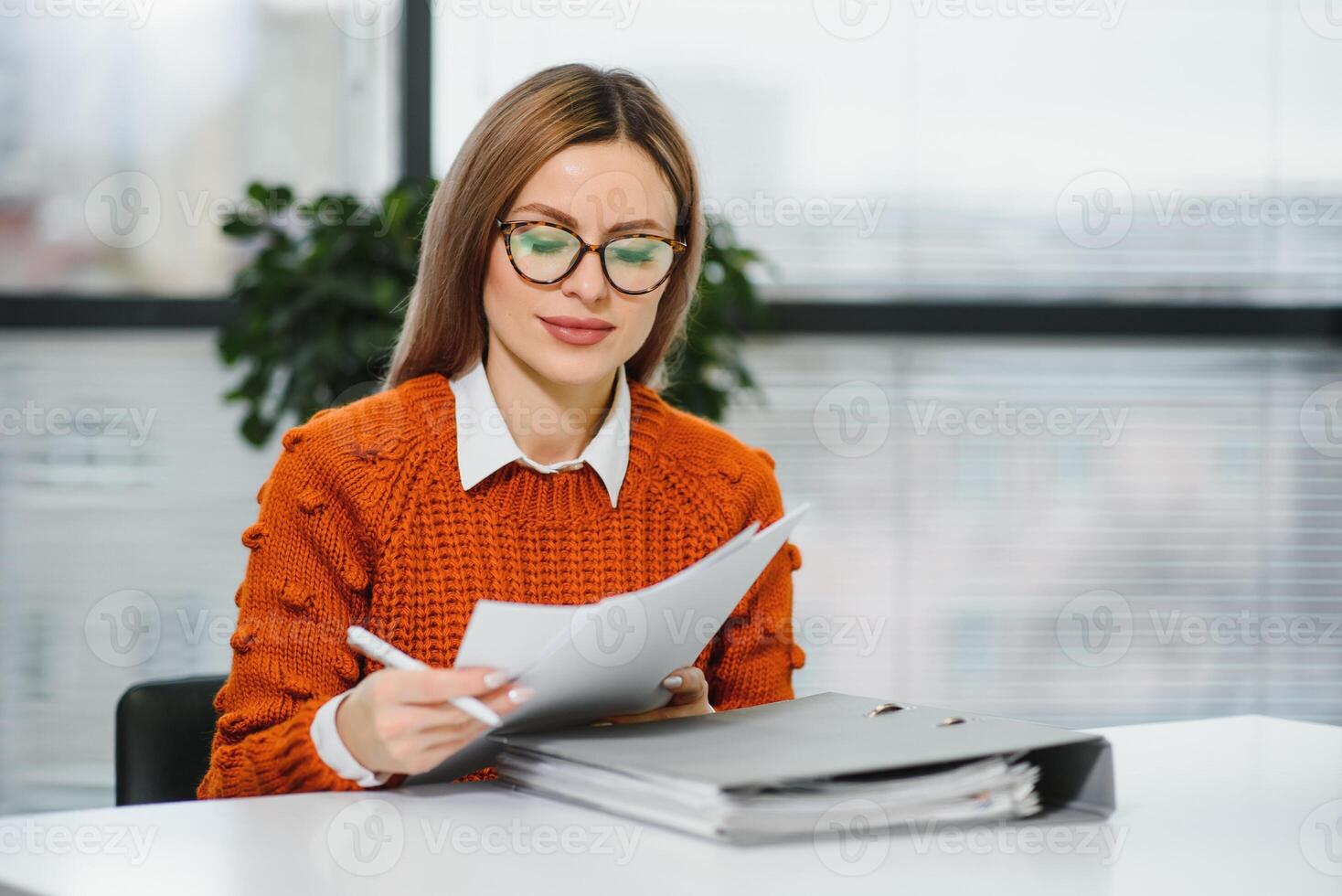 Happy smiling business woman at work talking on phone, sitting at her working place in office, copy space photo