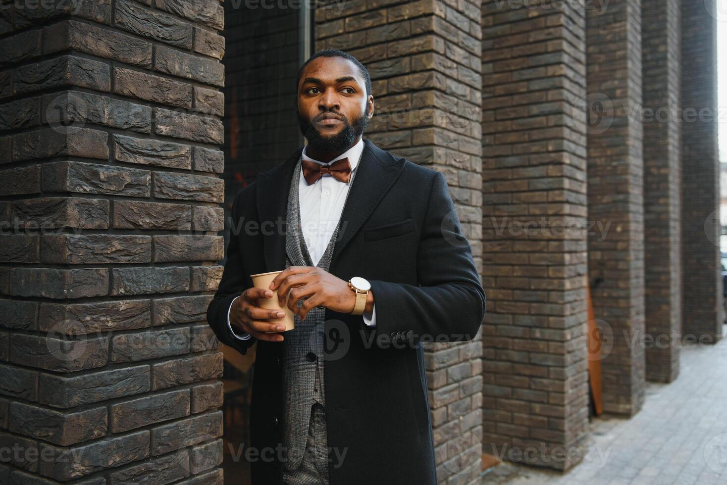 Young african american businessman drinking take away coffee at the city. photo