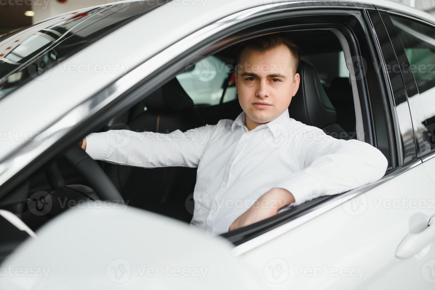 Portrait of an handsome smiling business man driving his car. photo