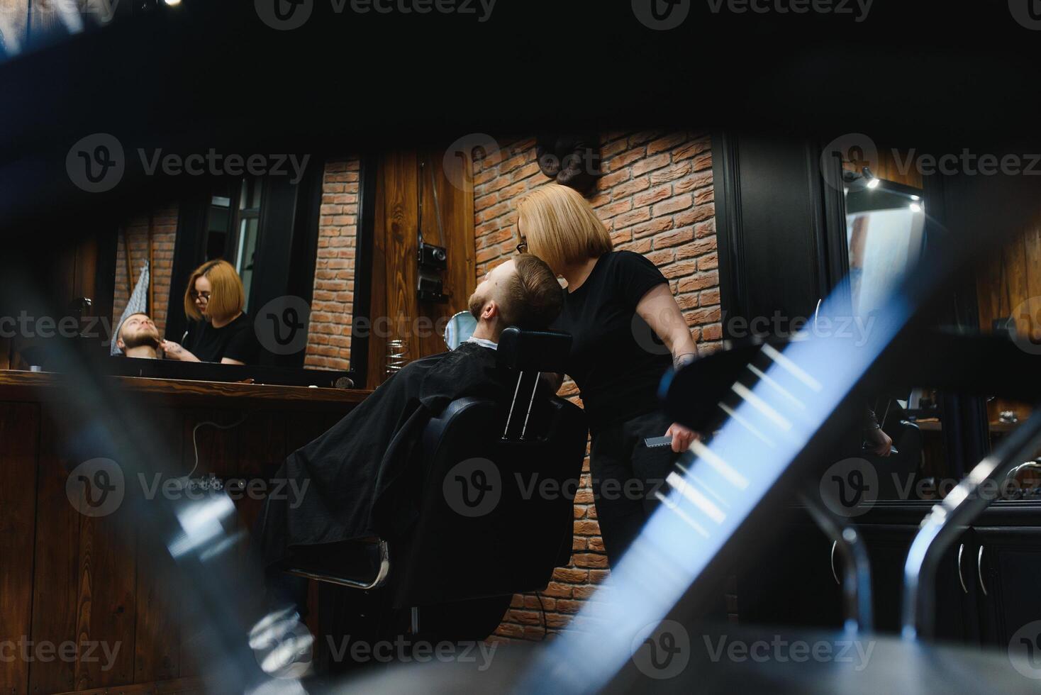 Barbershop or hairdresser concept. Woman hairdresser cuts beard with scissors. Man with long beard, mustache and stylish hair. Guy with modern hairstyle visiting hairdresser photo