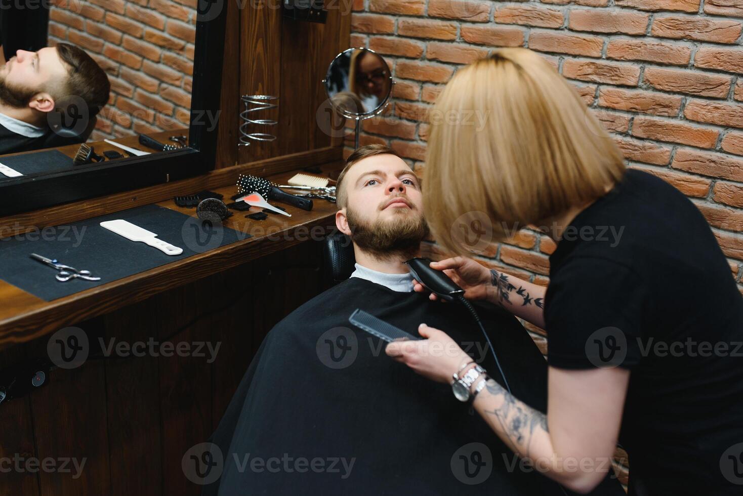 Client during beard shaving in barber shop photo