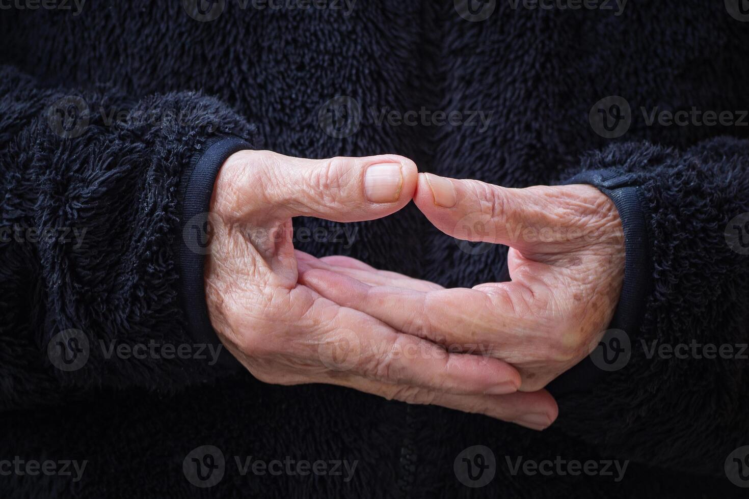 Close-up of wrinkled hands senior woman joined together for meditation. Concept of aged people and religion photo