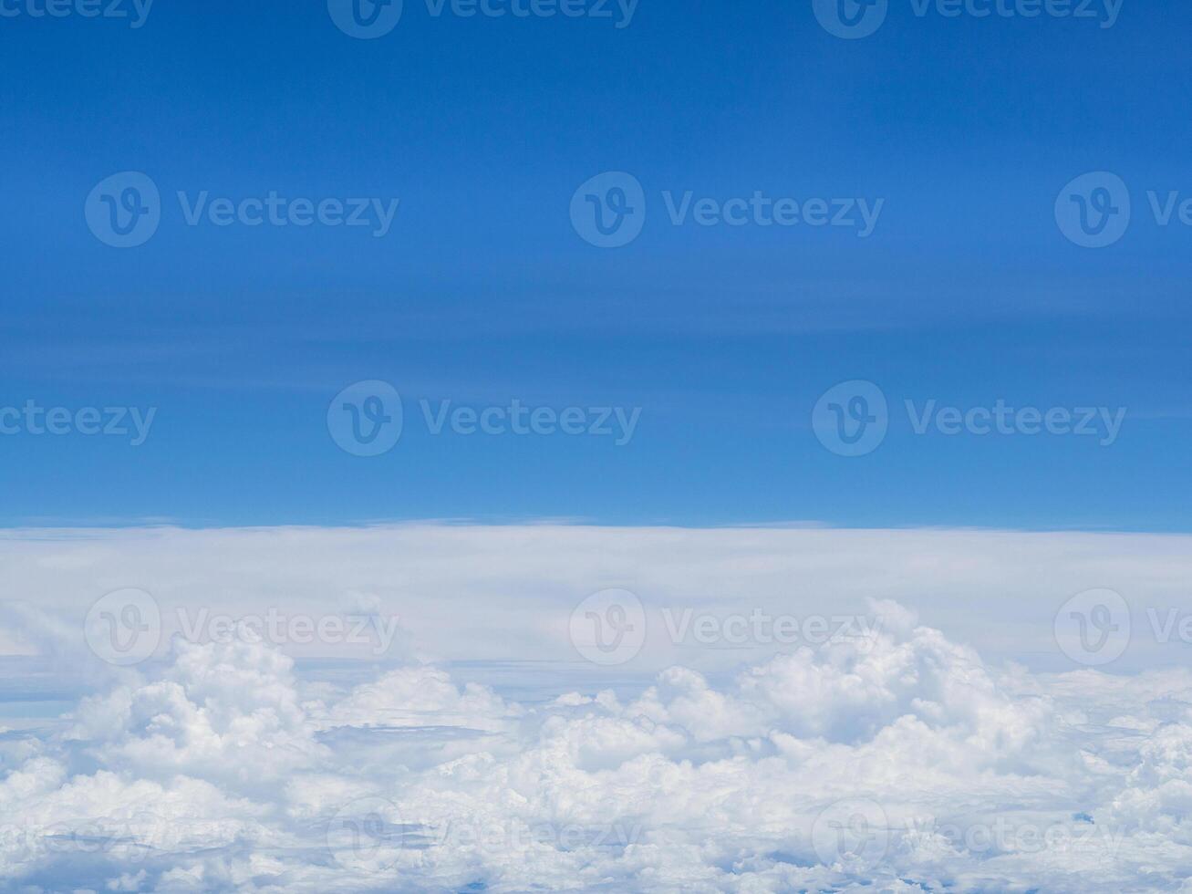 Aerial view of the sky and clouds are seen through the airplane window photo