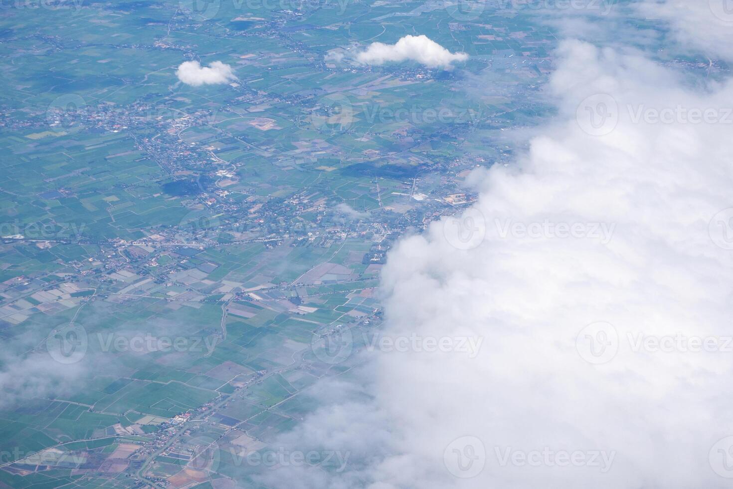 Aerial view of agricultural fields, river, mountains, and land have seen through the airplane window photo