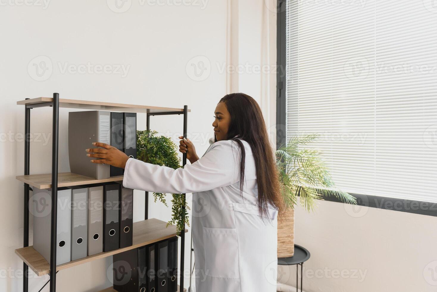 Young beautiful African American girl doctor in a white coat with a stethoscope. photo