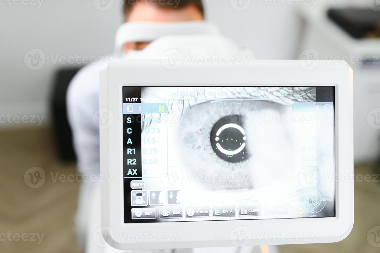 Handsome young man is checking the eye vision in modern ophthalmology clinic. Patient in ophthalmology clinic photo