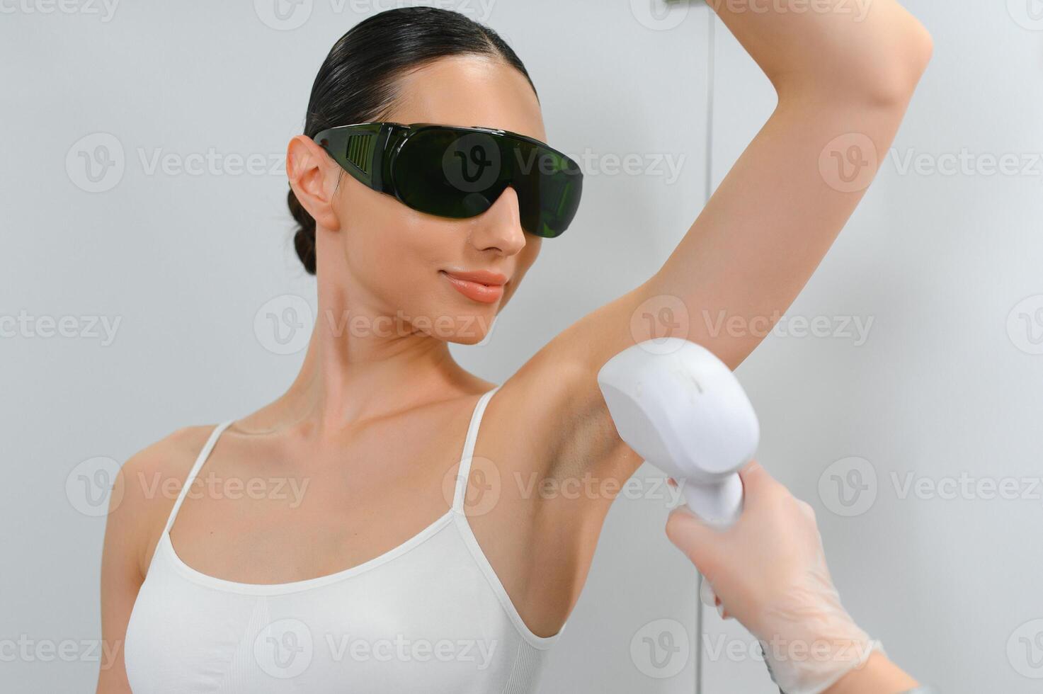 Young woman making body hair removal laser depilation in beauty center photo
