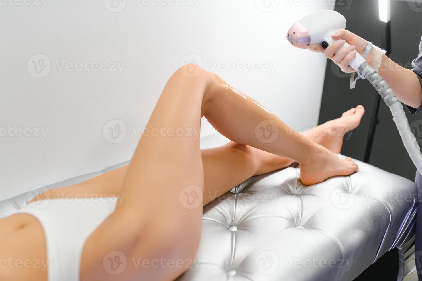 close-up of young caucasian slender woman getting laser epilation in beauty salon. photo