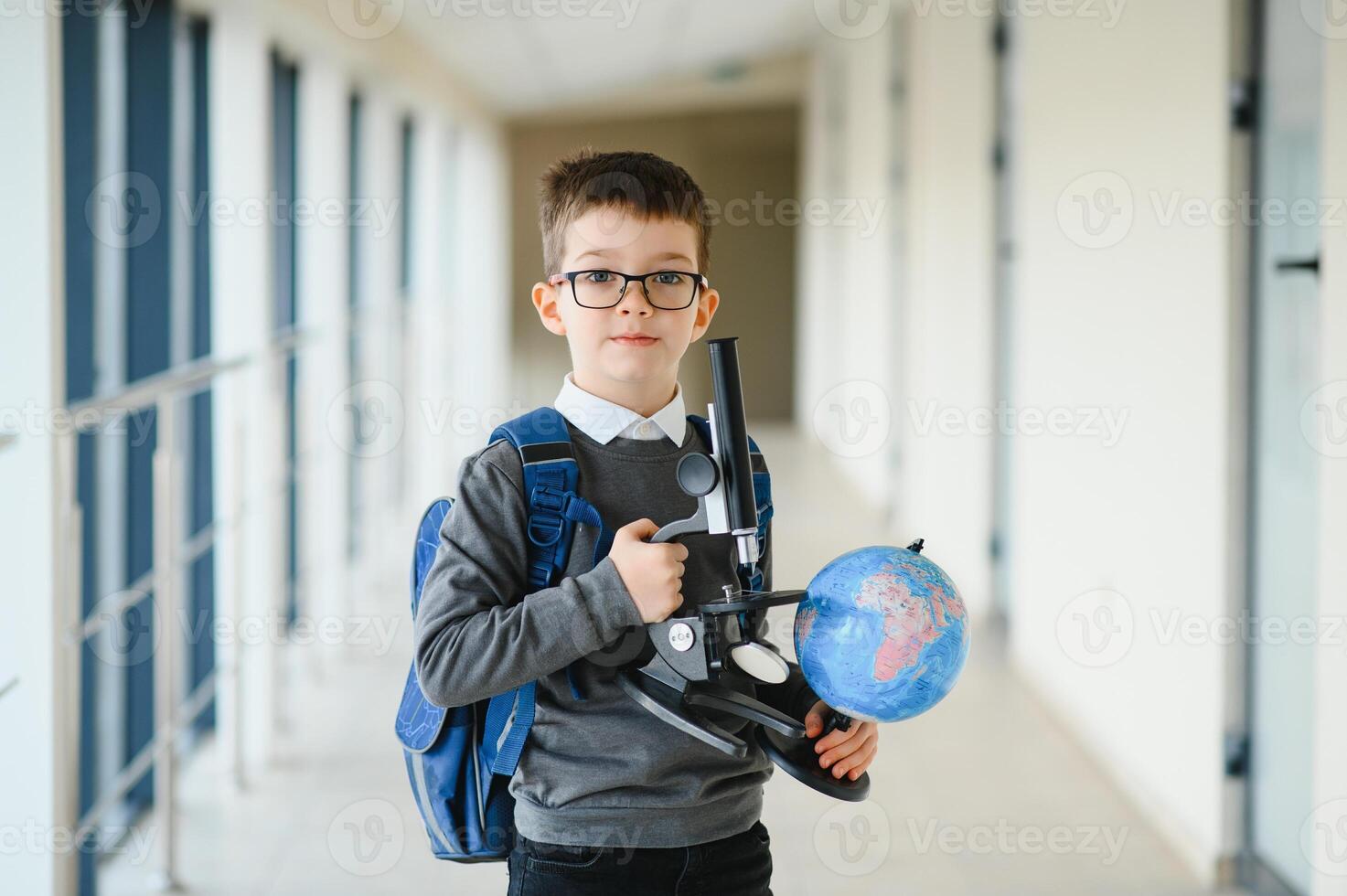 Schoolboy with schoolbag and books in the school. Education concept. Back to school. Schoolkid going to class. Stylish boy with backpack. Boy ready to study. photo