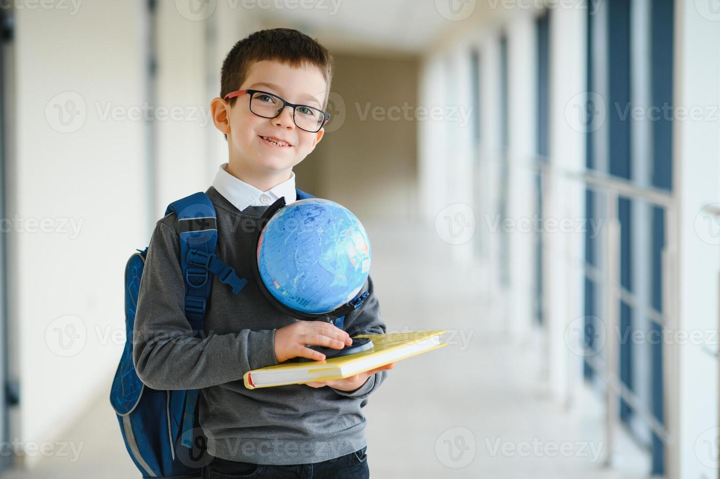 Happy cute clever boy in glasses with school bag and book in his hand. First time to school. Back to school. photo