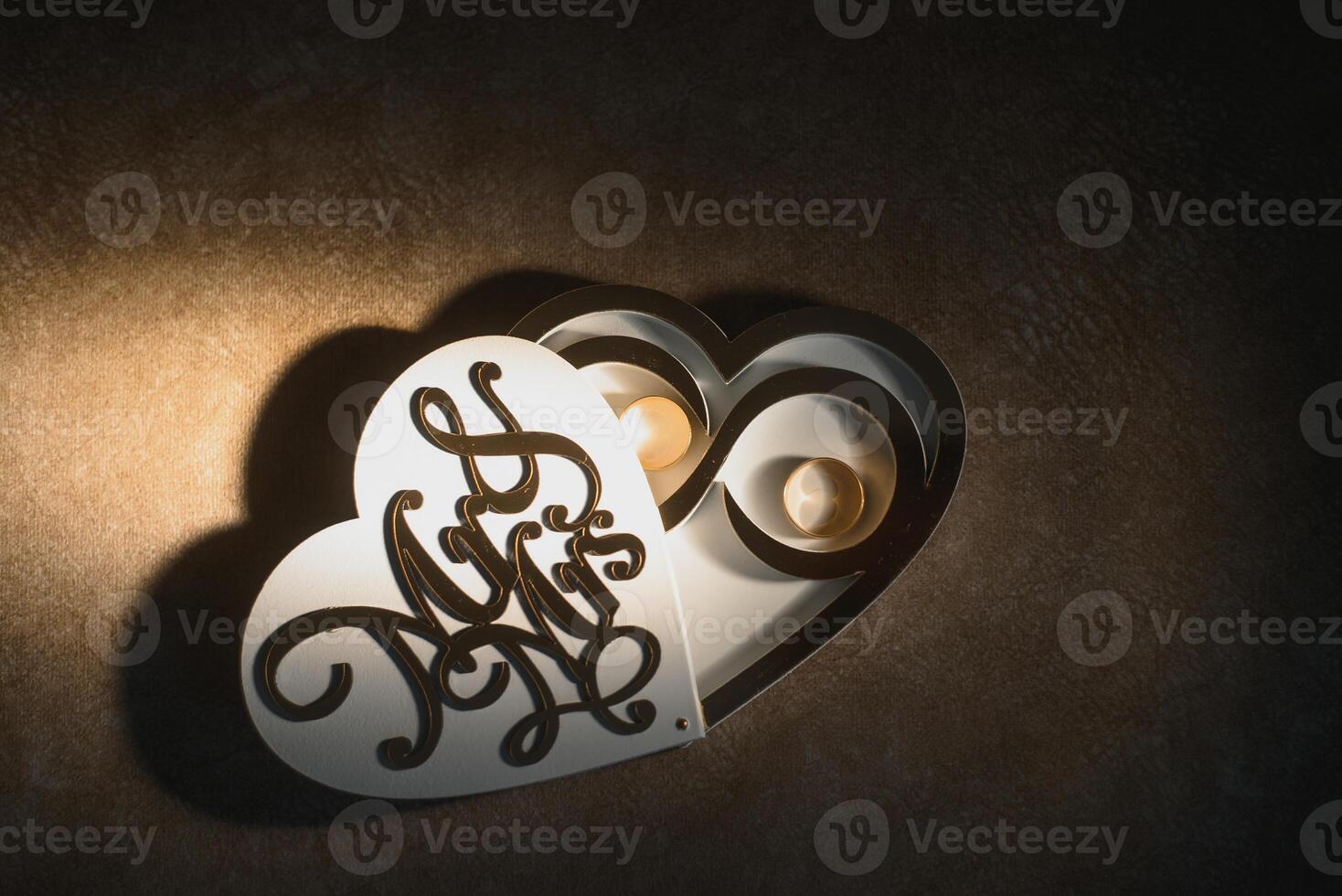 Elegant wedding rings for the bride and groom on a black background with highlights, macro, selective focus. photo