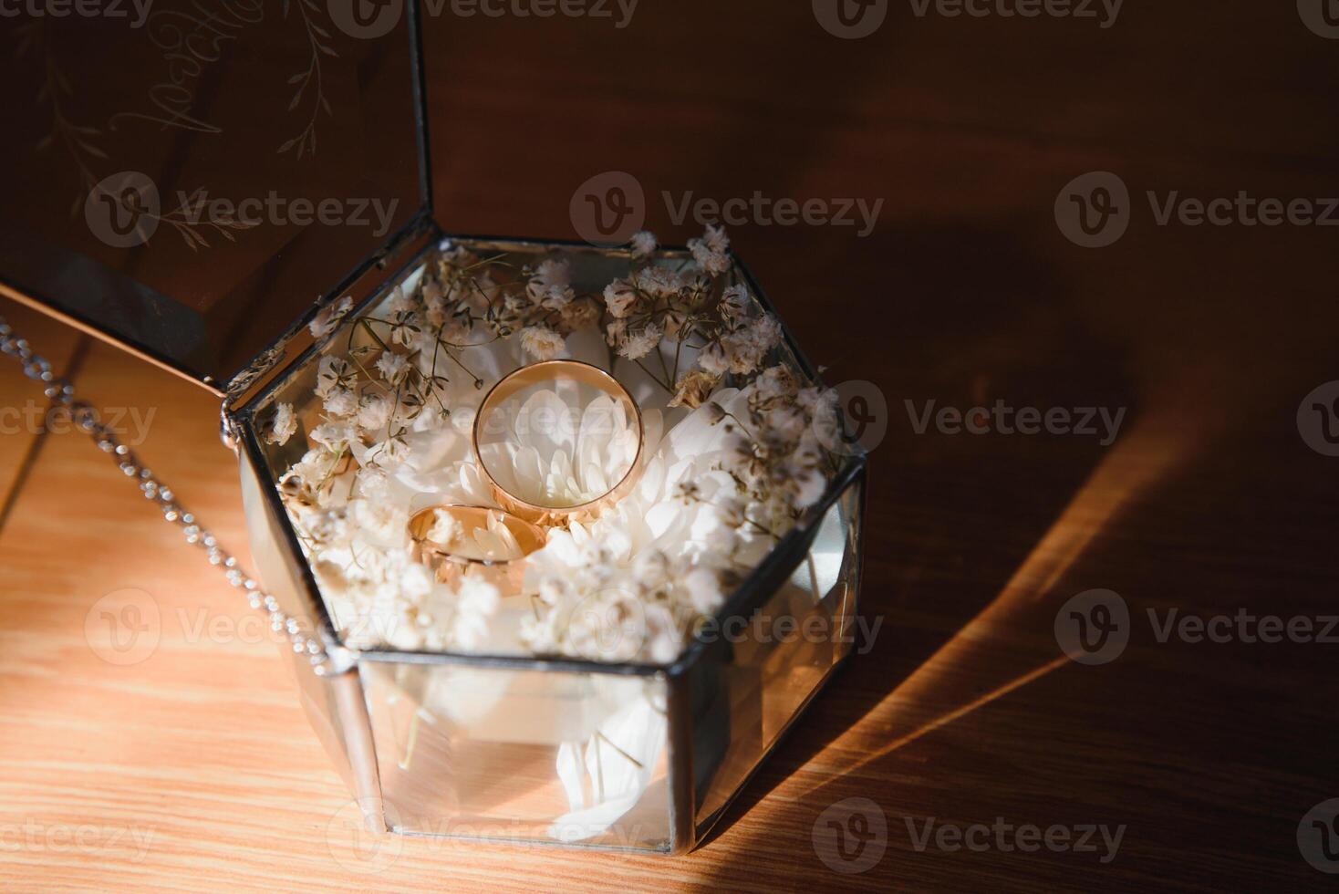 Elegant wedding rings for the bride and groom on a black background with highlights, macro, selective focus. photo