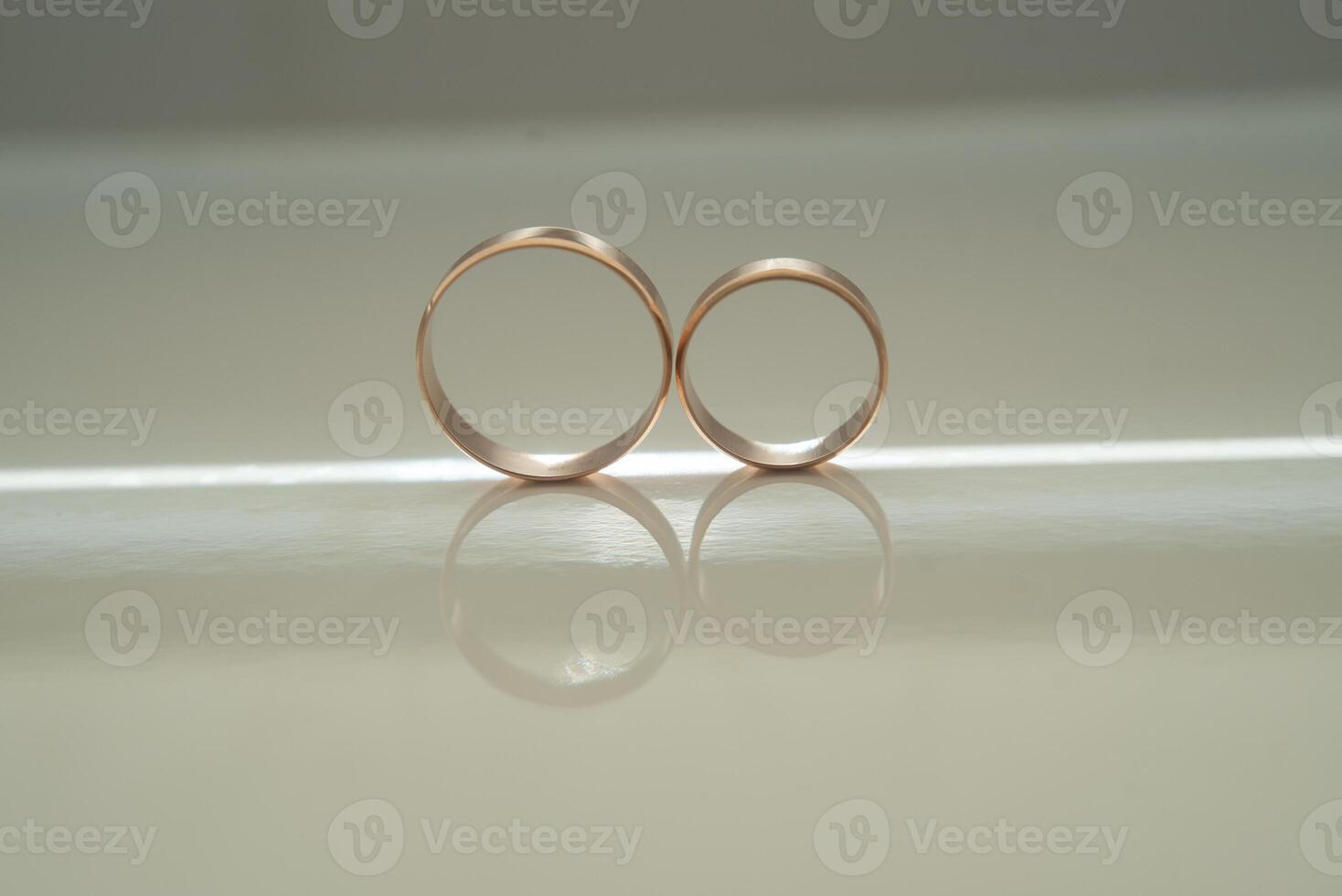 Elegant wedding rings for the bride and groom on a black background with highlights, macro, selective focus. photo