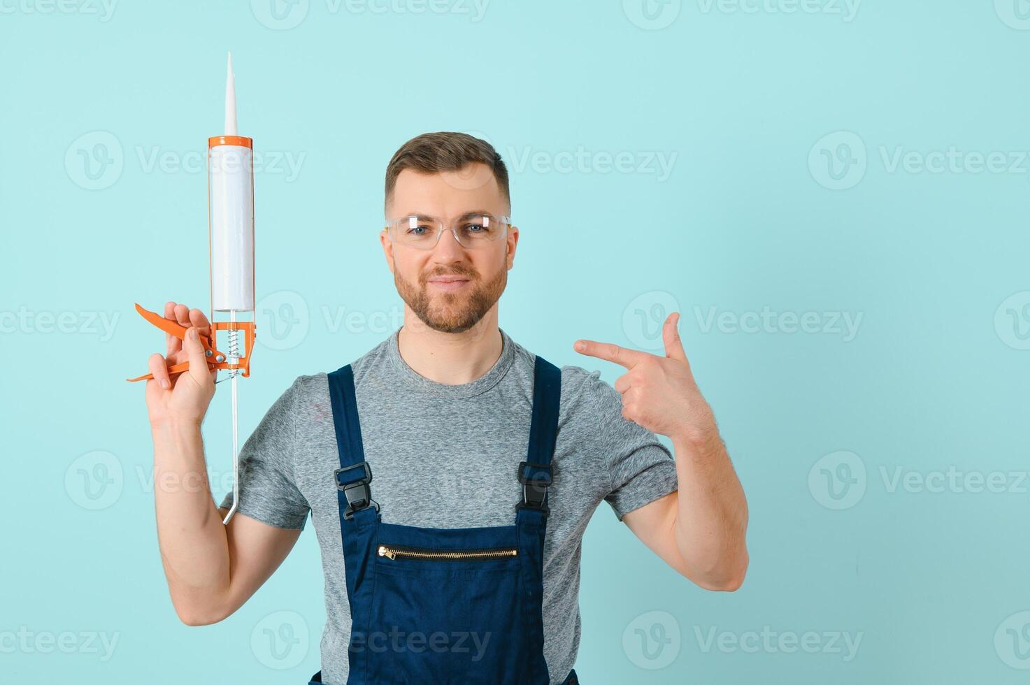 Close-up portrait of his he nice attractive cheerful cheery content guy repairer craftsman isolated over blue color background. photo