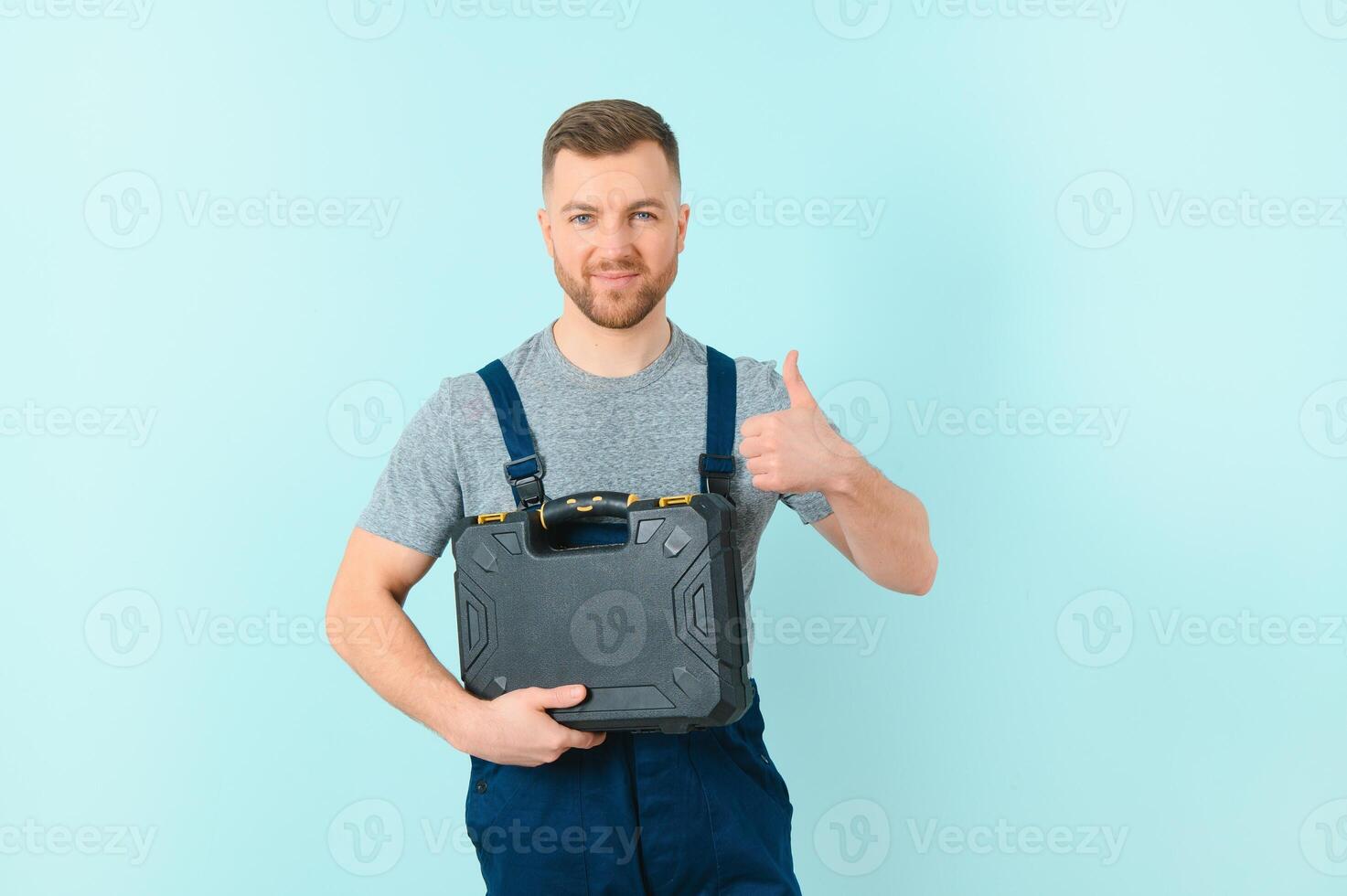Craftsmen or electrician man over isolated blue background giving a thumbs up gesture photo