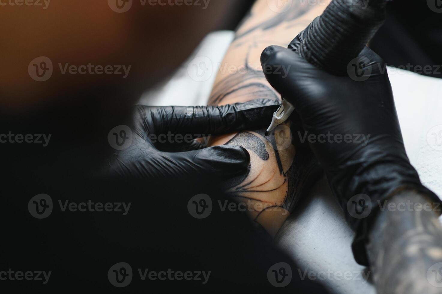 tattooist with his machine tattooing on the arm with the design drawn, concept of art and design photo