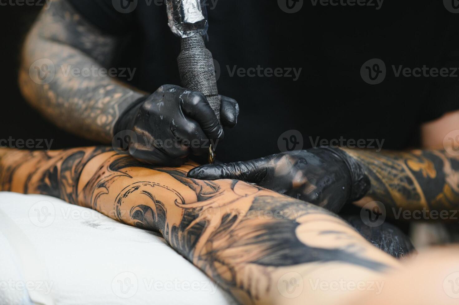 Tattoo salon. The tattoo master is tattooing a man. Tattoo machine, safety and hygiene at work. Close-up, tinted, tattooist. photo