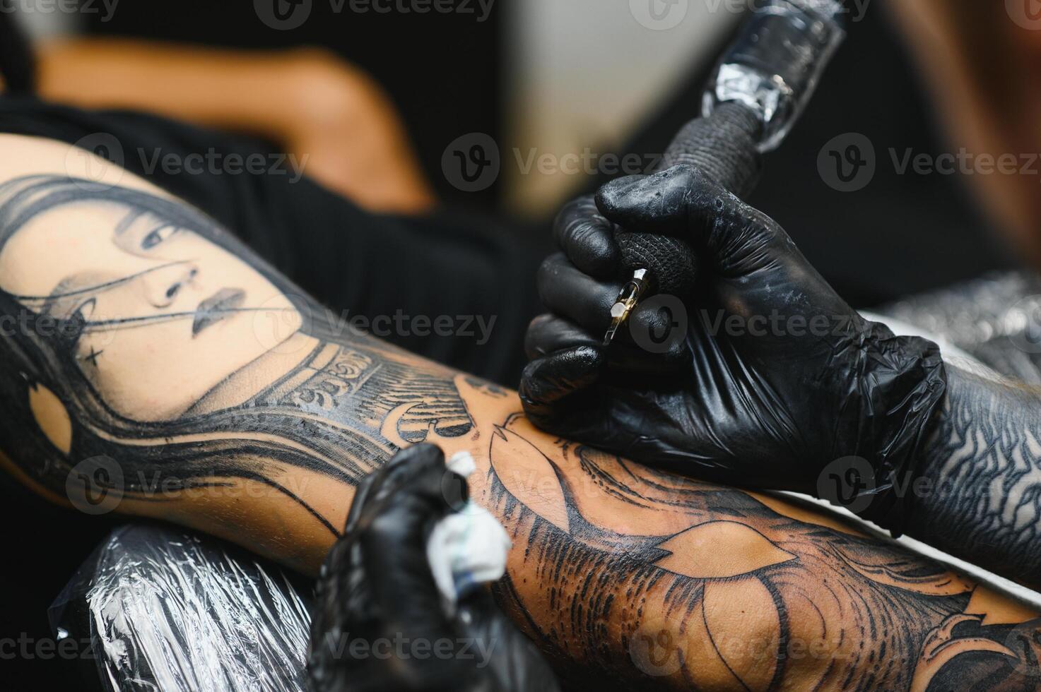 Tattoo salon. The tattoo master is tattooing a man. Tattoo machine, safety and hygiene at work. Close-up, tinted, tattooist. photo