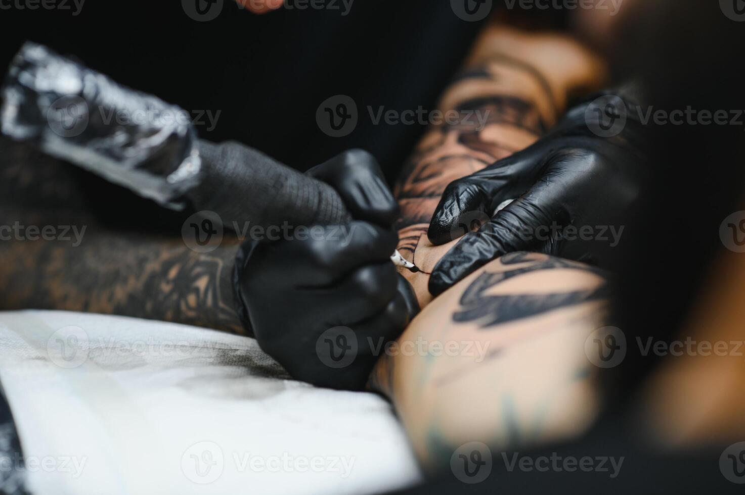 tattooist with his machine tattooing on the arm with the design drawn, concept of art and design photo