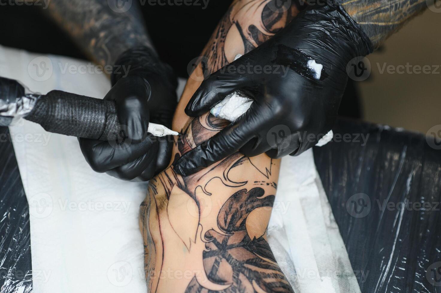 tattooist with his machine tattooing on the arm with the design drawn, concept of art and design photo