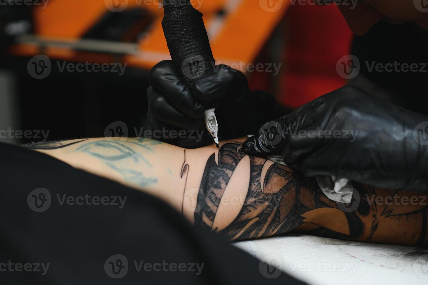 Close up of the tattoo machine. Tattooing. Man creating a picture on his back by a professional tattoo artist. photo
