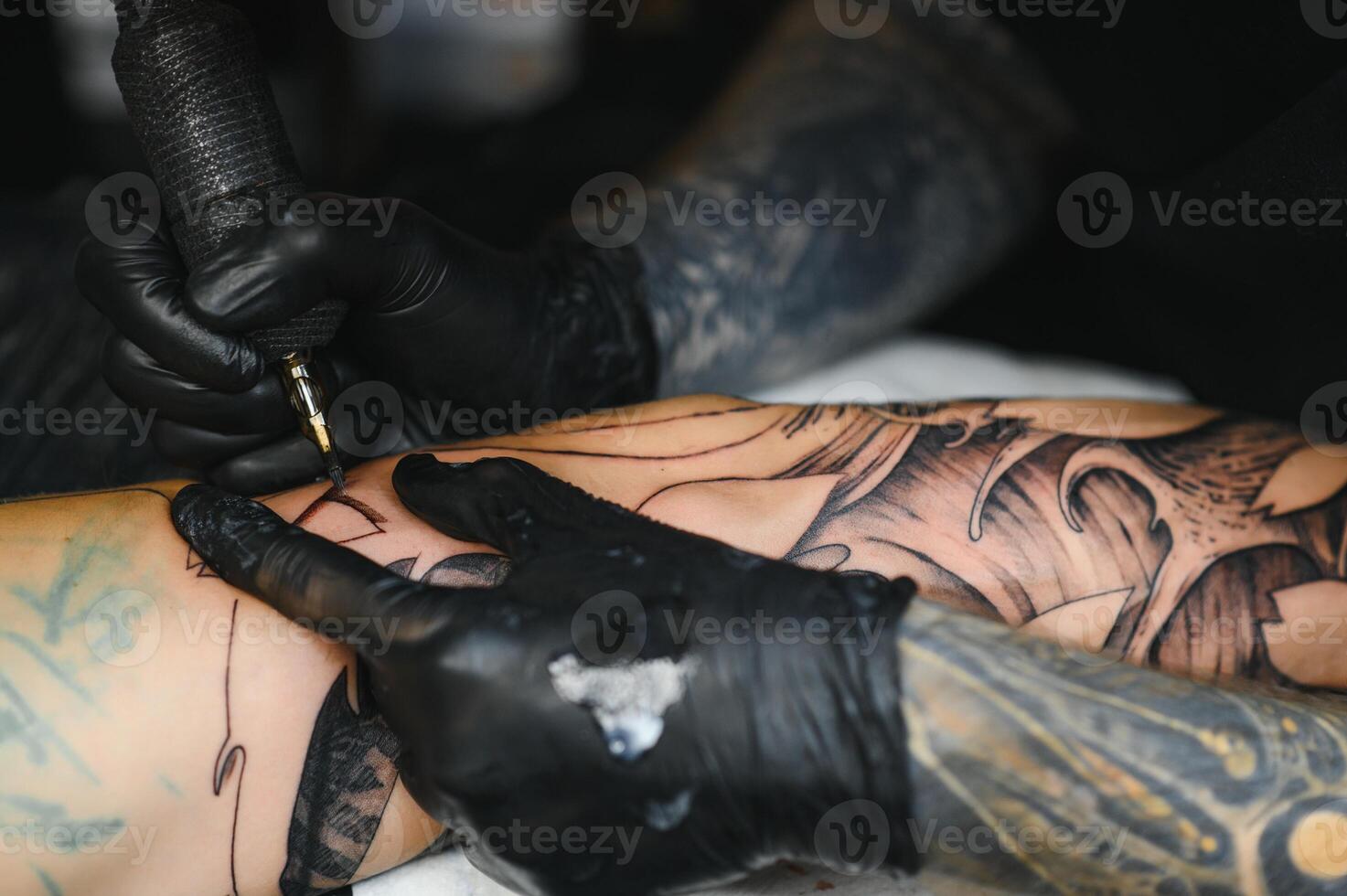 Professional tattoo artist working in his tattoo studio. photo