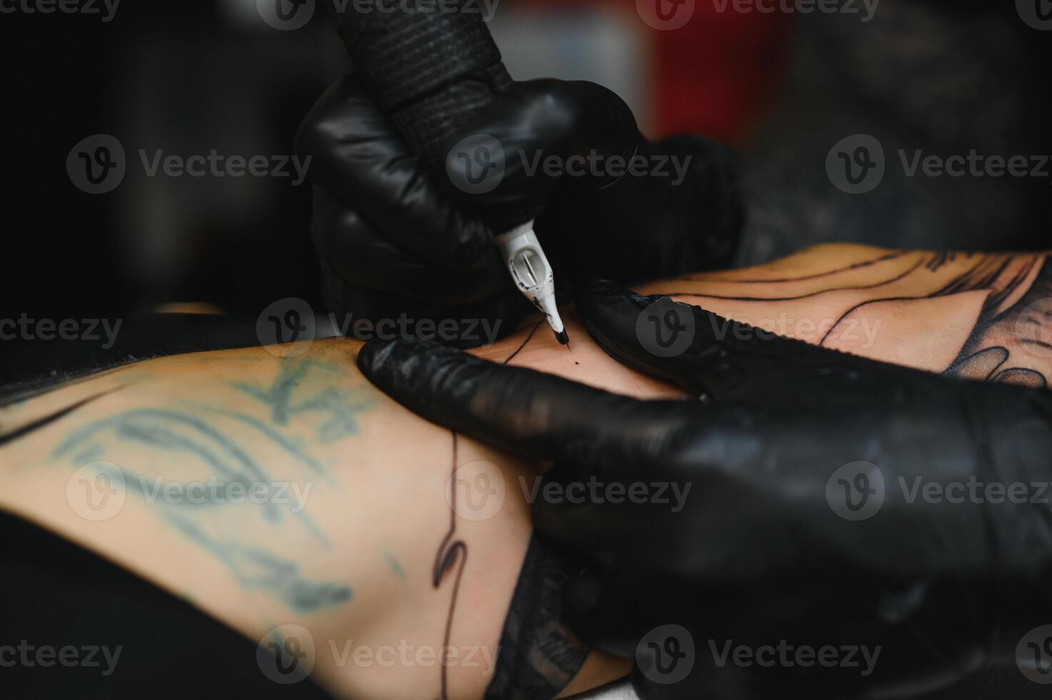 Tattoo salon. The tattoo master is tattooing a man. Tattoo machine, safety and hygiene at work. Close-up, tinted, tattooist. photo