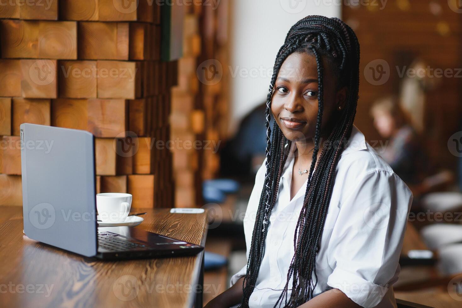 Happy african american woman worker using laptop work study at computer in loft office or cafe, smiling mixed race female student freelancer using pc app dating communicating online watching webinar photo
