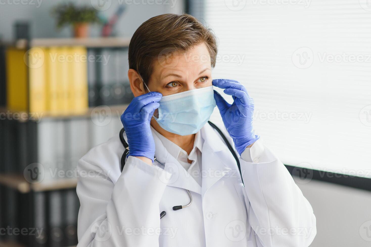 Doctor in mask with stethoscope in hospital. photo