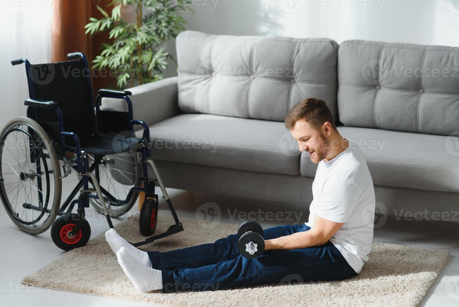 Man Disabled. Sports for Disabled. Male in Wheelchair with Dumbbells in Hands. Man with Dumbbells in Hands. Father Disabled Do Spotting. Sport at Apartment. Health Concept. Healthy Lifestyle photo