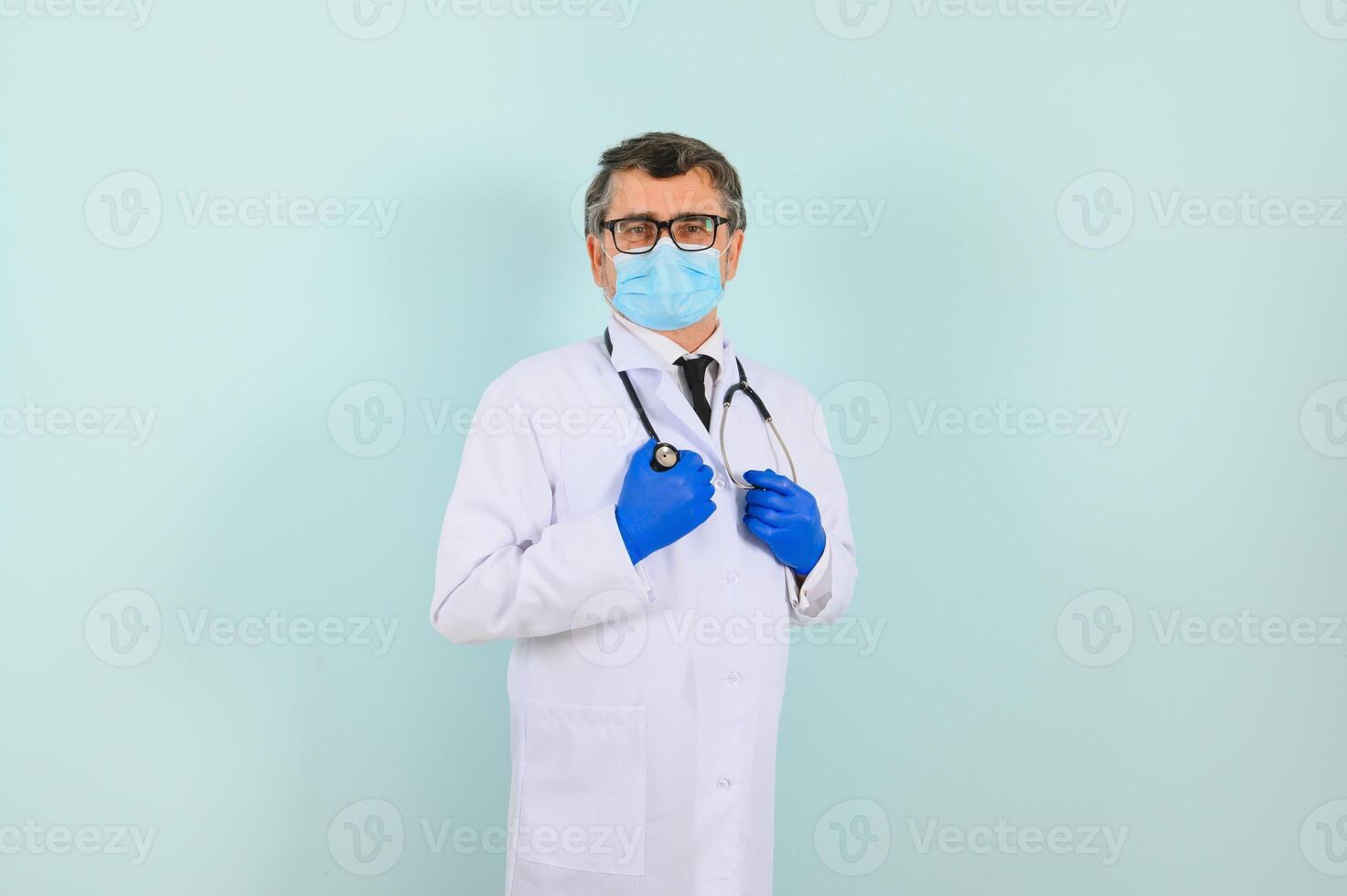 Portrait of a male doctor in a mask and gloves on a blue background. Healthcare concept photo