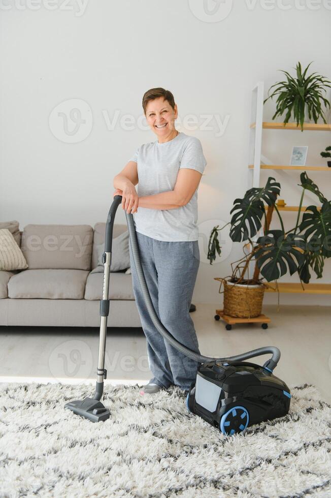 Cleaning concept. woman cleaning carpet with vacuum cleaner. photo