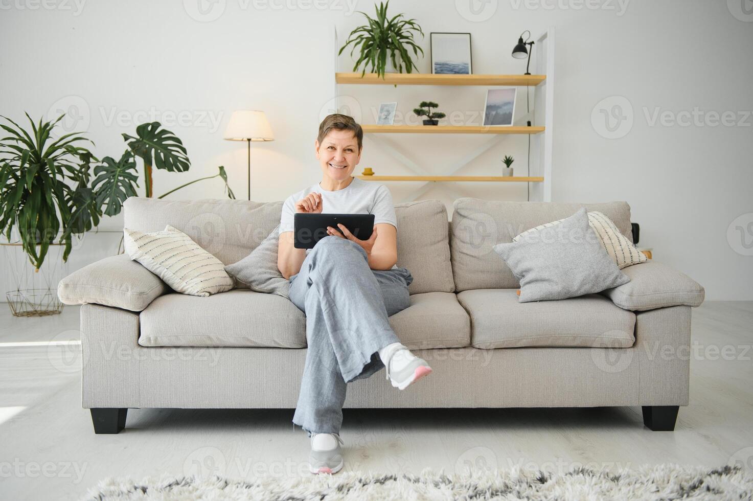 people, technology and internet concept - happy middle aged woman with tablet pc computer at home. photo