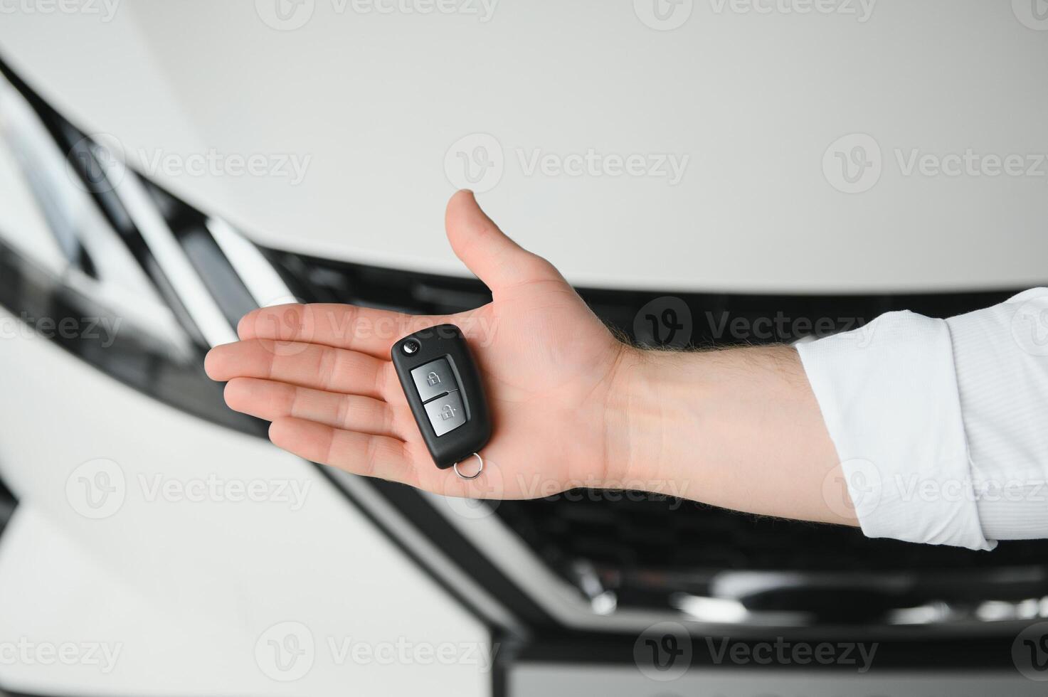 Close up of the car owner's hand holding the delivery key to buyers. Concept of selling cars and giving keys to new owners photo