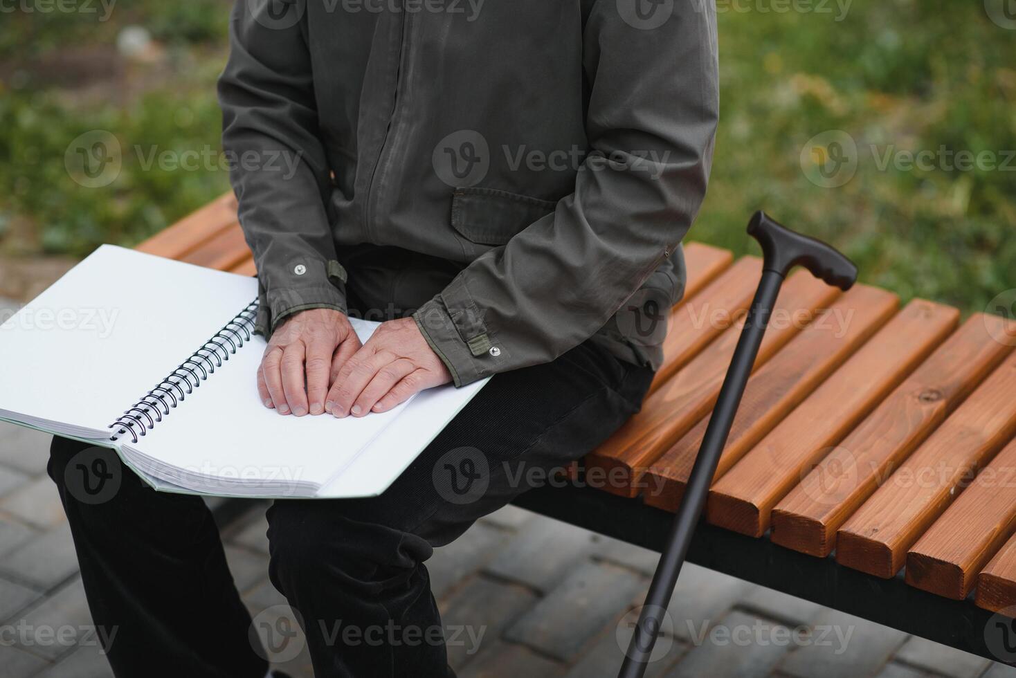 Blinded man reading by touching braille book photo