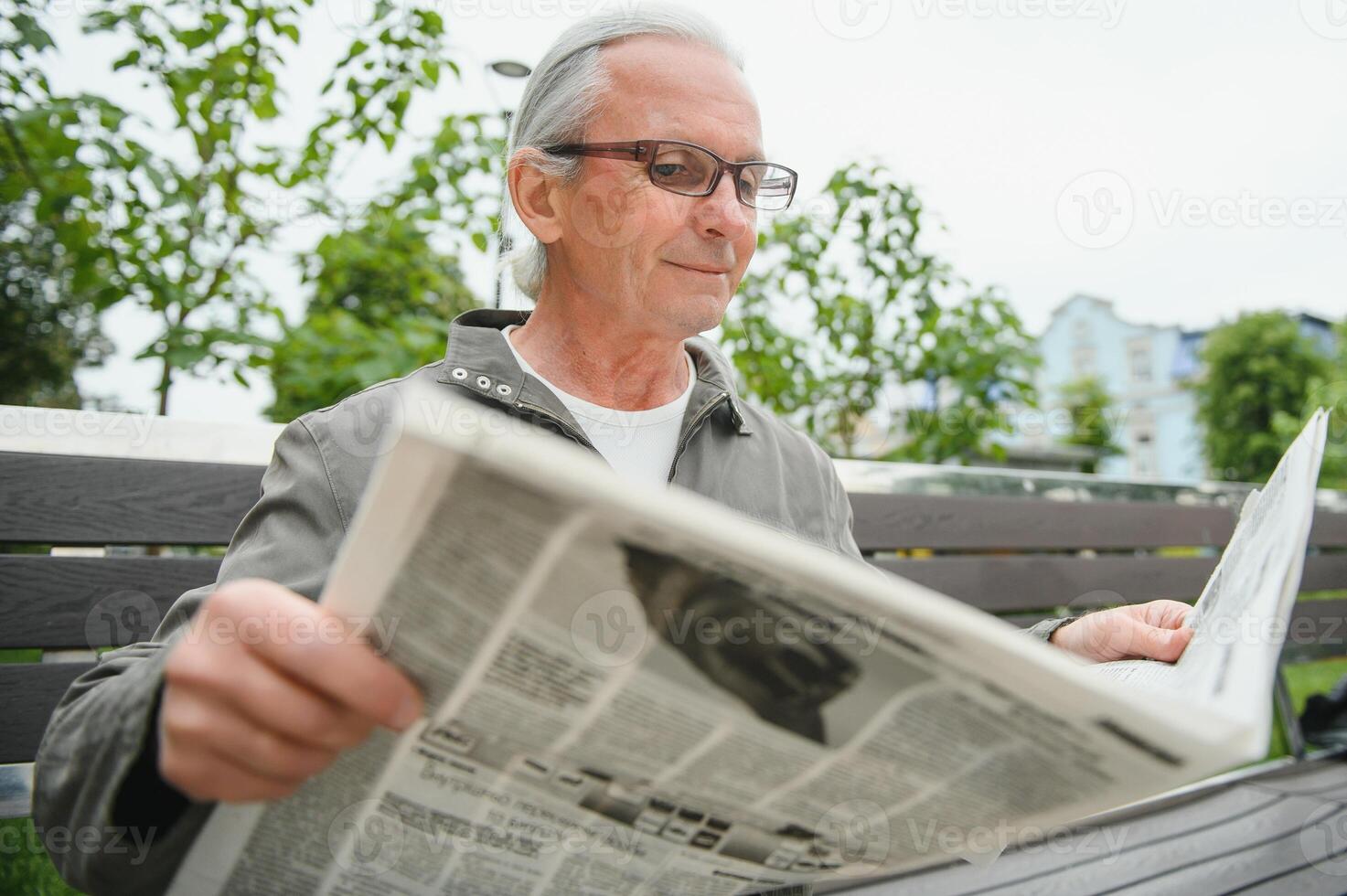 Old gray-haired man rest on the bench in summer park photo