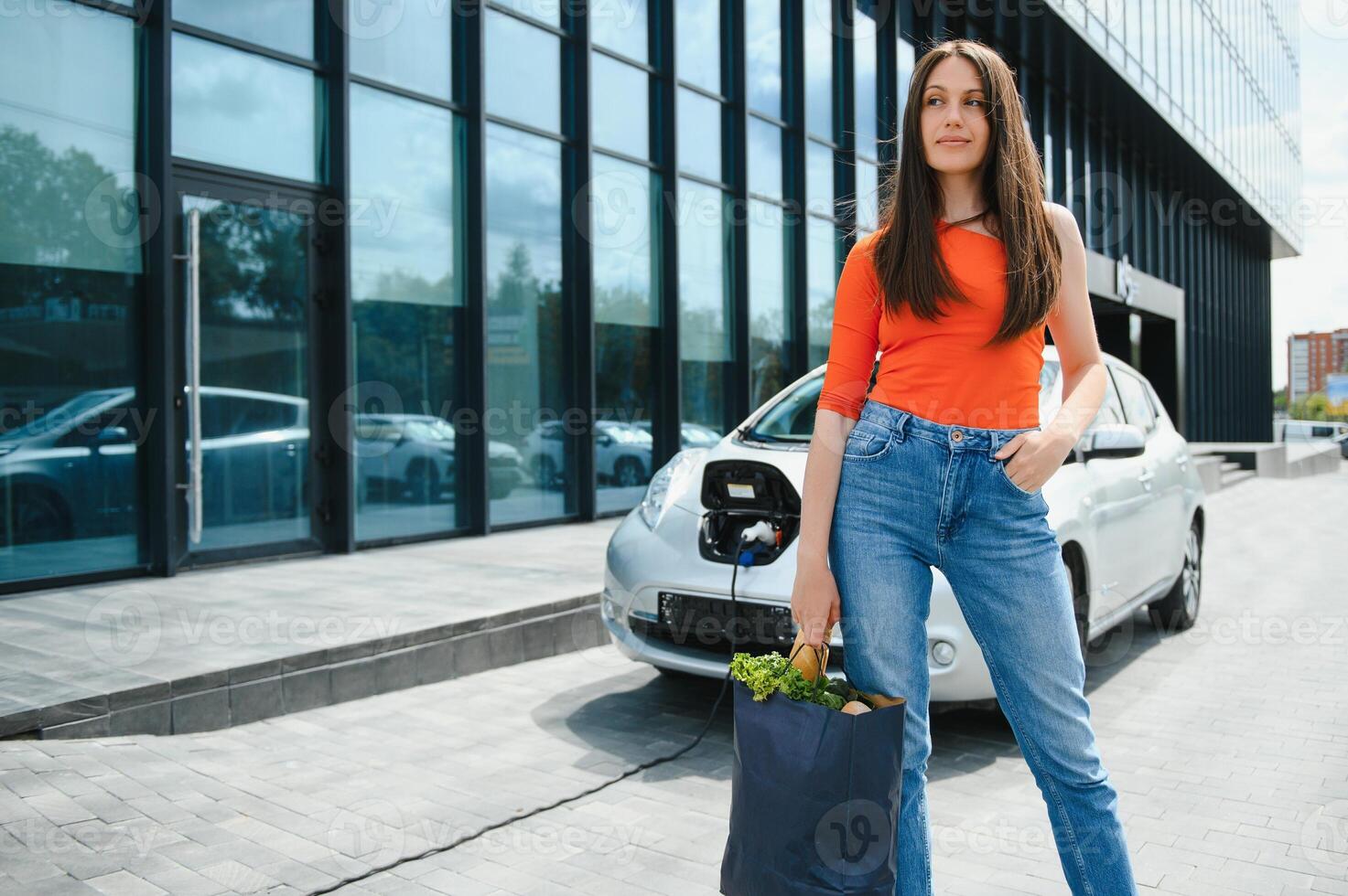 Woman charging electro car at the electric gas station photo