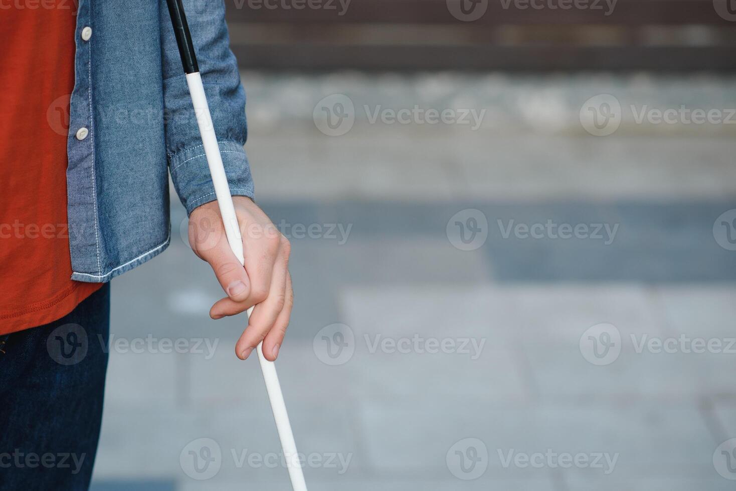Handsome blind man walks around the city. photo