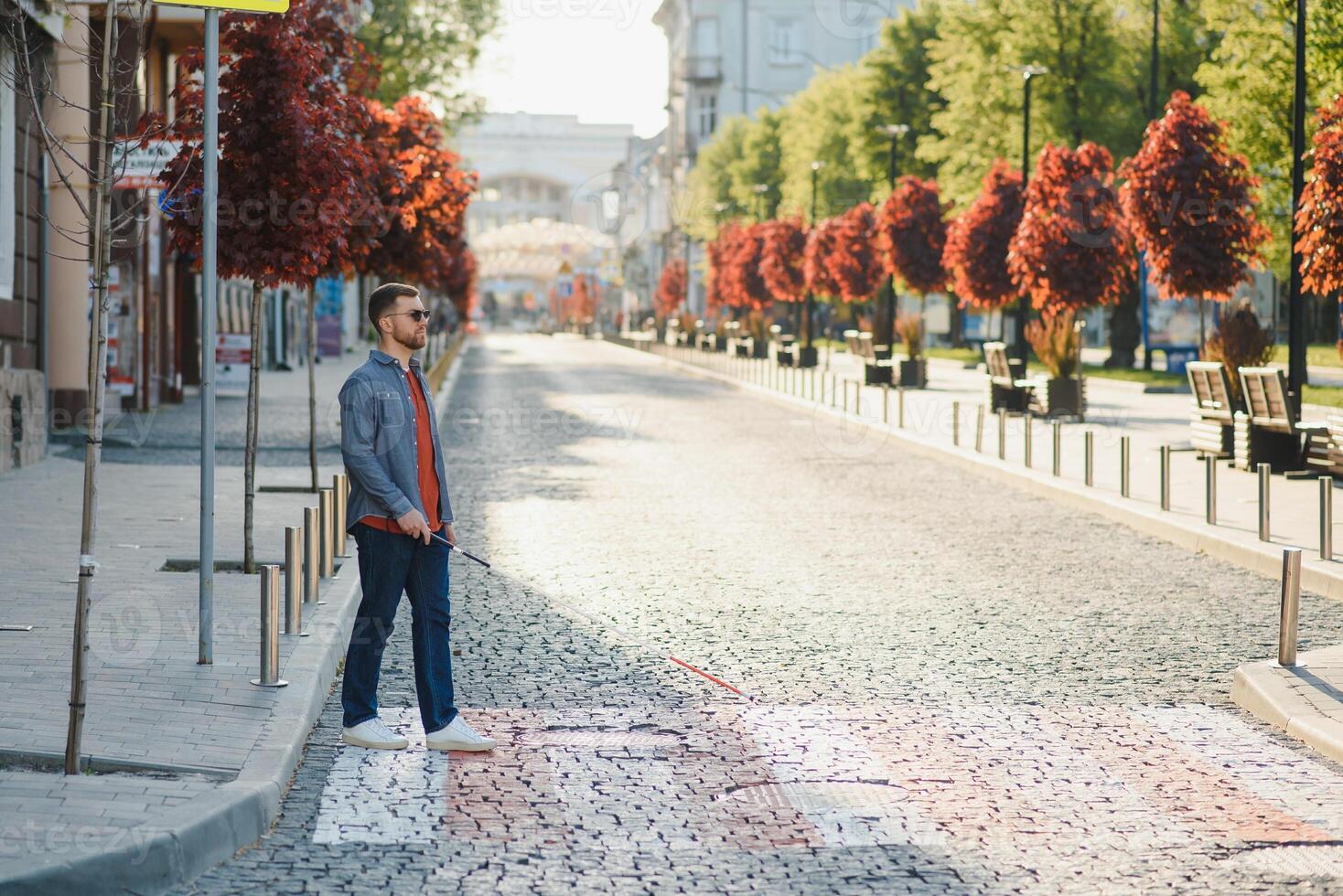 Blind Man Walking On Sidewalk Holding Stick photo