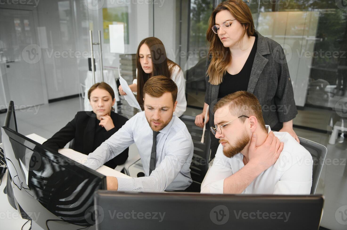 Smiling business people sitting at a desk in front of a laptop computer photo