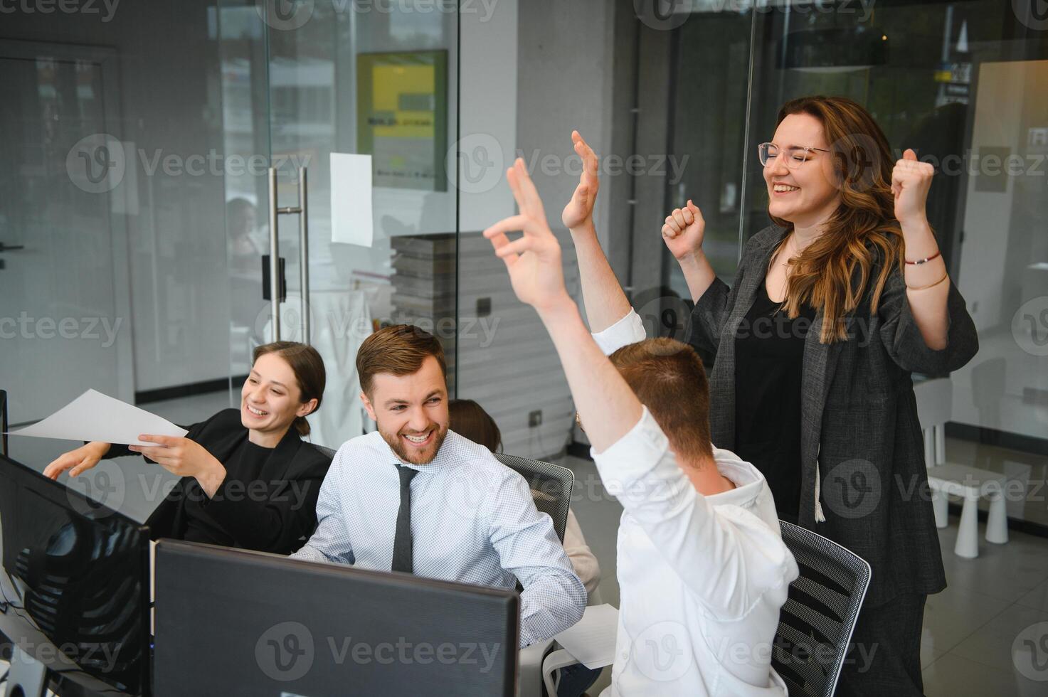 Smiling business people sitting at a desk in front of a laptop computer photo