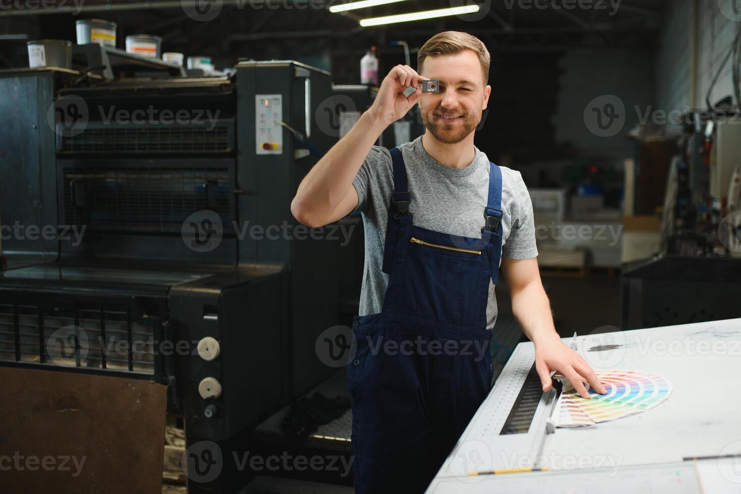Funny portrait of typographer standing with color swatches at the printing manufacturing photo