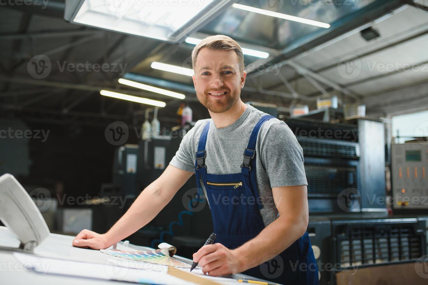 Funny portrait of typographer standing with color swatches at the printing manufacturing photo